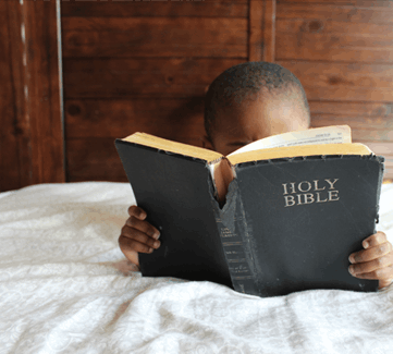 Kind liest in der Bibel Kind liest in der Bibel